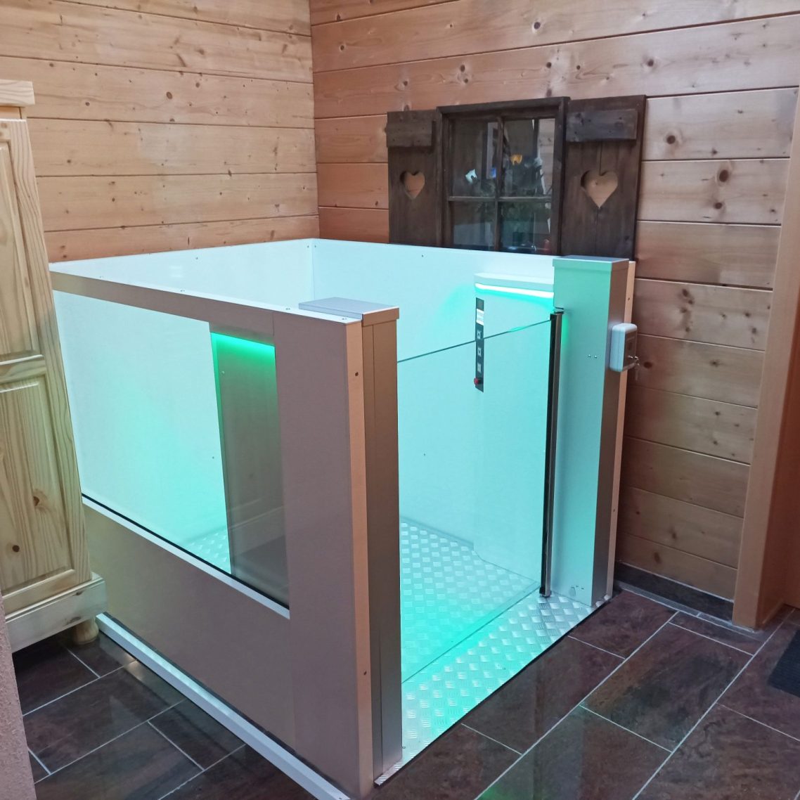 Moderne Hublifte aus Glas mit sanfter Beleuchtung in einem rustikalen Raum.